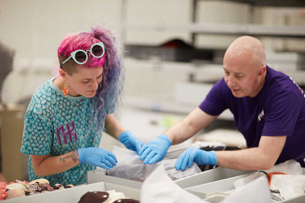 A man and a woman look at the contents of a box