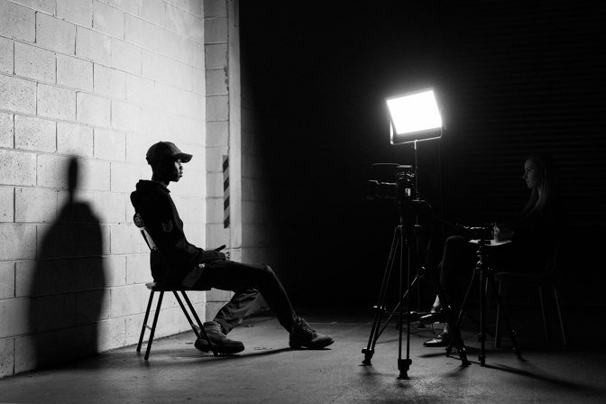 Black and white image of a person being interviewed on camera