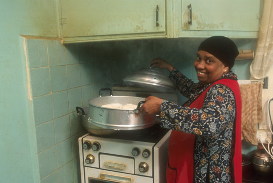 Woman cooking on an old style stove