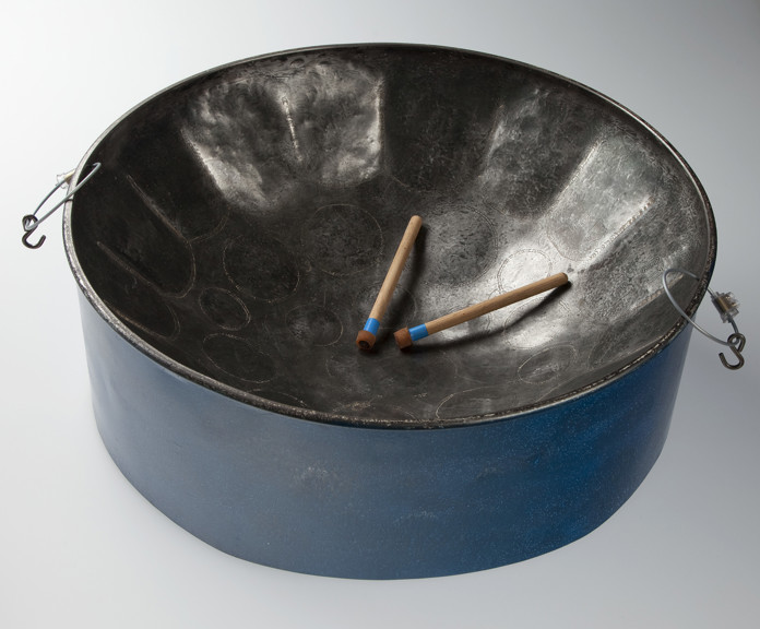 A steel pan with blue sides and a concave top with drum sticks on top of it