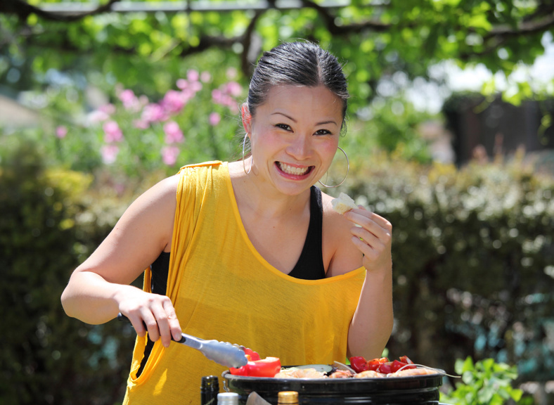 Asian woman cooking on a barbecue
