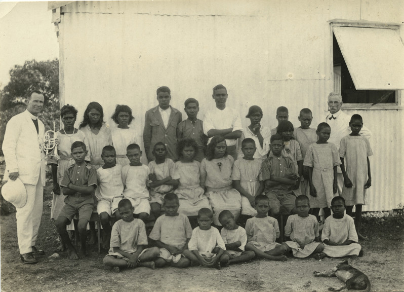 Black and white photograph of a group of Aboriginal children with 2 white men in suits