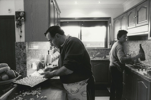Black and white photograph of a man and woman cooking in a 1970s style kitchen