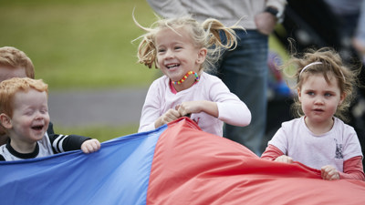 Children holding a colourful parachute at Little Kids' Day In at Scienceworks, June 2017