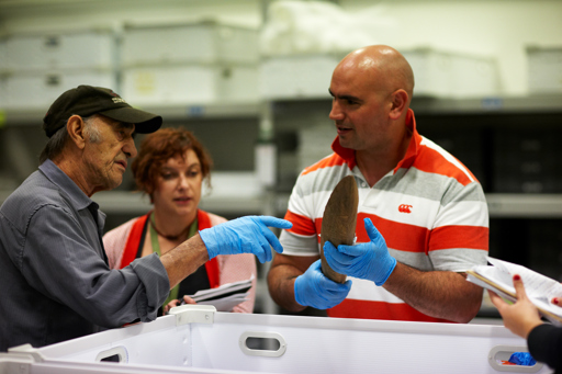 Elder Albert Mullet talking with designer Corinne Balaam and collection manager John Duggan about a shield in the First Peoples collection store.
