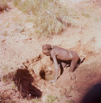 Pintupi man, clearing out Lola Well, in the sand dunes near Labbi Labbi rockhole, Western Australia