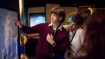 Students in the Road to Zero Experience Space interact with a touch screen.