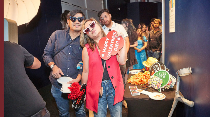 People enjoying the Valentine's Day themed events at Scienceworks with a photo-booth corner set up, complete with props.