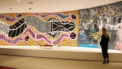 A person viewing the large mural artworks in Birrarung Gallery