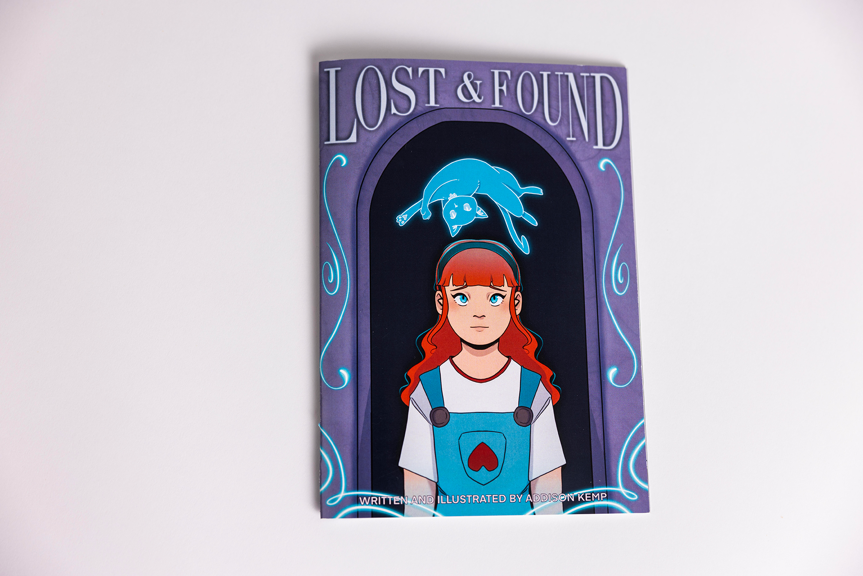 Book cover featuring an illustrated girl with long red hair, wearing blue and white. A blue cat floats above her head.