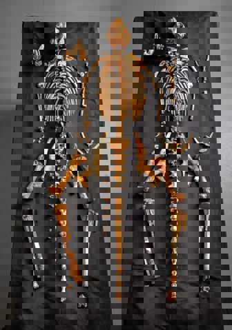 A collection of orange bones laid out on a black tablecloth in the shape of a skeleton