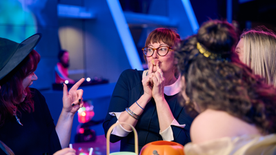 A woman dressed as a witch presses a love-shaped Jello to her mouth.