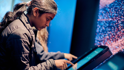 A student interacting with a touch screen in the Road to Zero Experience Space 