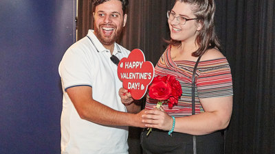 People enjoying the Valentine's Day themed events at Scienceworks with a photo-booth corner set up, complete with props.