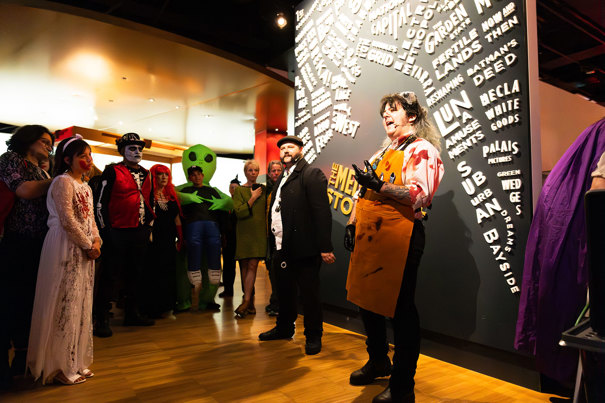 A museum tour guide dressed as a bloody butcher talks to audiences about horrible histories during Halloween at the Museum.