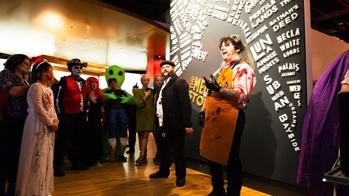 A museum tour guide dressed as a bloody butcher talks to audiences about horrible histories during Halloween at the Museum.