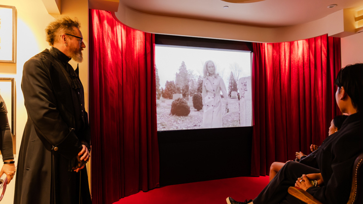 People watching a B-grade horror film in the Haunted Cinema during Halloween at the Museum, Melbourne Museum.
