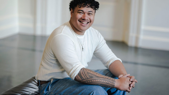 Logan Tapuala sitting and smiling at the camera.