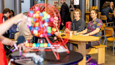 A bingo wheel is turned as seated players look on.