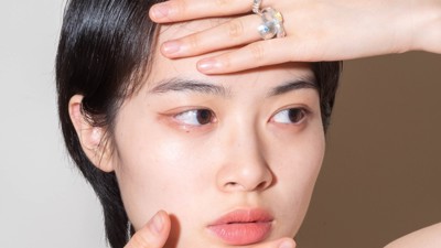 Amy Yang showcasing an assortment of silver rings with colourful gemstones on her hands.