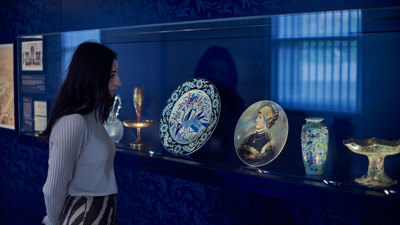 A woman looking at ornate plates on display in the basement of the Royal Exhibition Building.