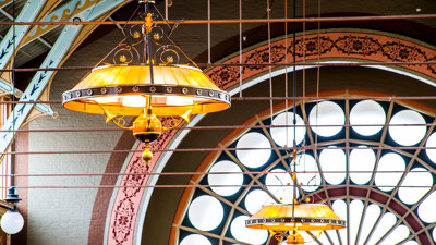 Ornate bespoke gas-powered lamps handing from the ceiling of the Royal Exhibition Building.