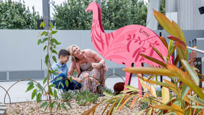 Boy and his mother near a large pink emu cut out in the Gandel Gondwana Garden