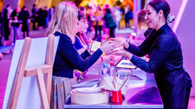 People purchasing cocktails and food from the bar at Nocturnal, Melbourne Museum.
