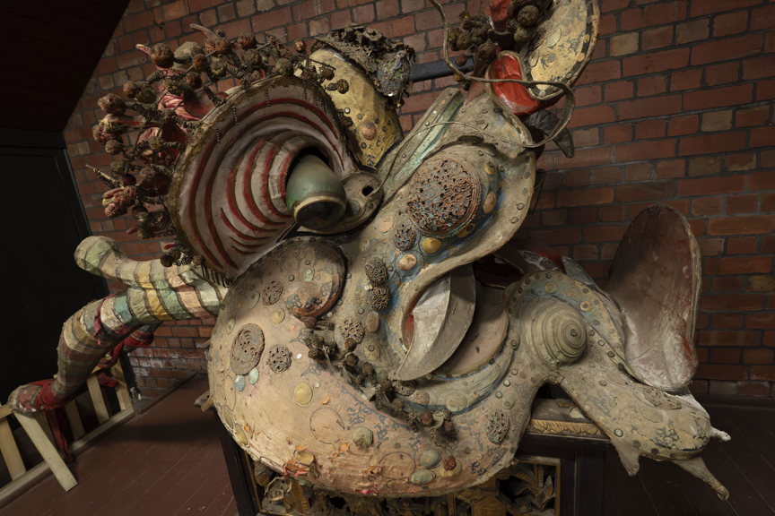 the head of a Chinese dragon resting on a plinth